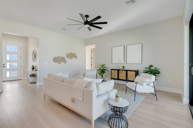 living room with ceiling fan and light hardwood / wood-style flooring