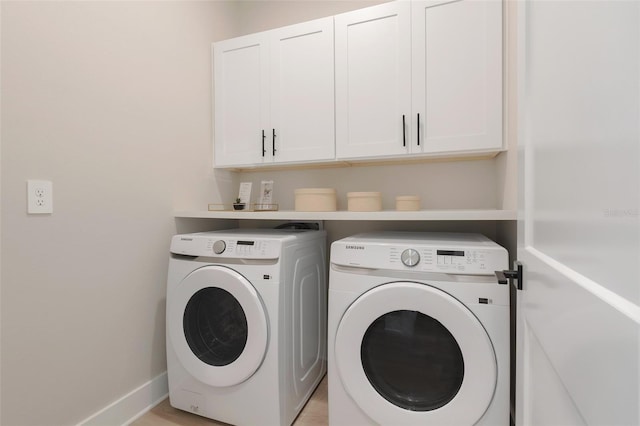 washroom with washer and clothes dryer and cabinets