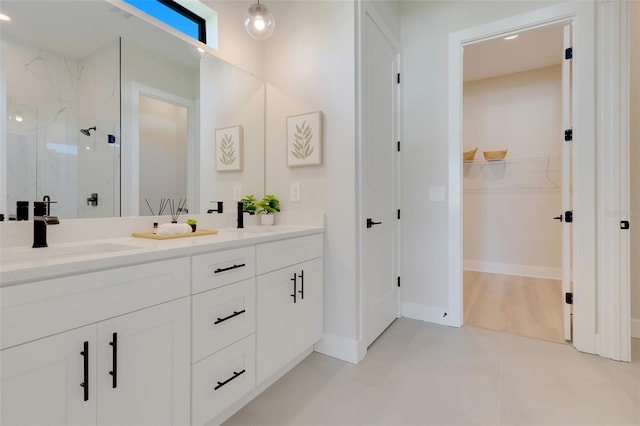 bathroom featuring vanity, a tile shower, and tile patterned floors