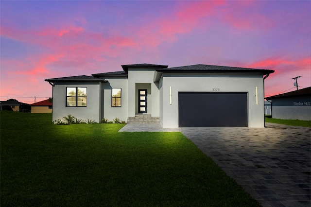 view of front of house with a garage and a yard