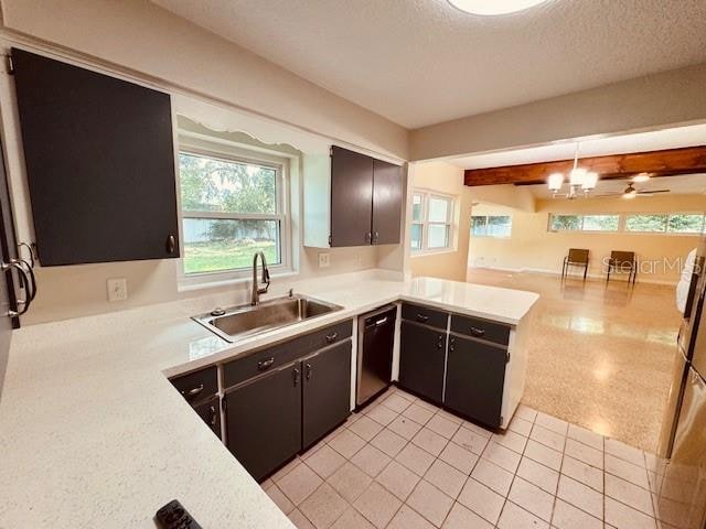 kitchen featuring sink, dishwasher, a textured ceiling, kitchen peninsula, and decorative light fixtures