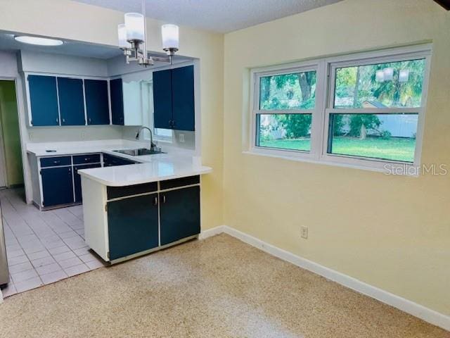 kitchen featuring sink, kitchen peninsula, decorative light fixtures, and an inviting chandelier