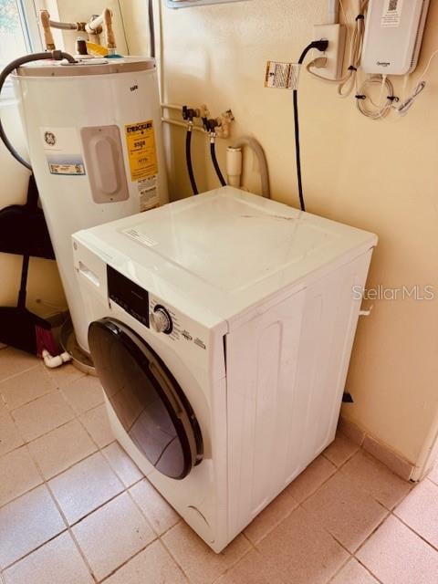 washroom featuring washer / dryer, light tile patterned floors, and water heater