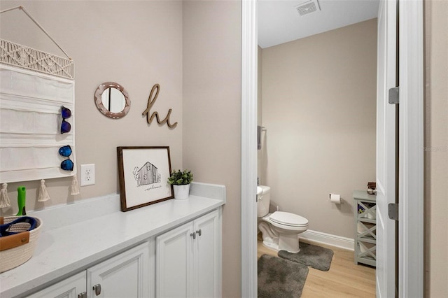 bathroom featuring hardwood / wood-style flooring, vanity, and toilet