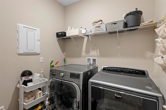 clothes washing area with electric panel and washing machine and dryer