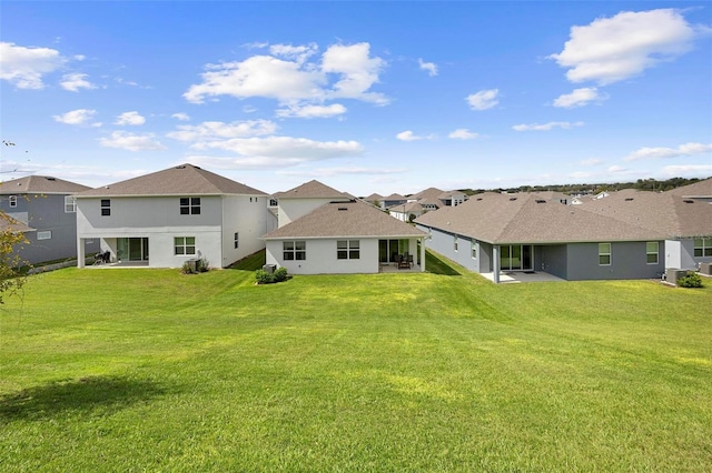 back of property with a yard and a patio