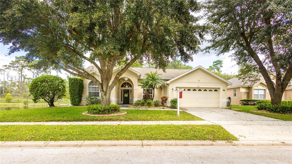 view of front of home with a garage and a front lawn