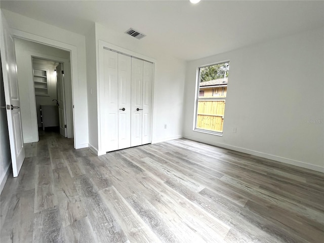 unfurnished bedroom featuring hardwood / wood-style flooring and a closet