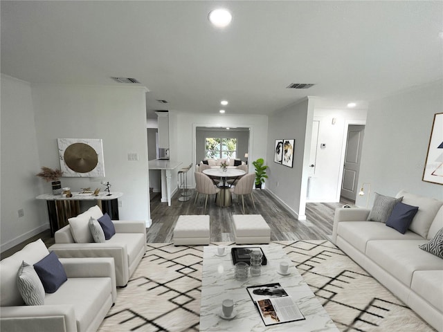 living room featuring crown molding and light hardwood / wood-style flooring