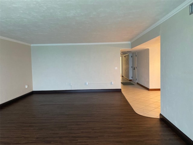 empty room featuring wood-type flooring and crown molding