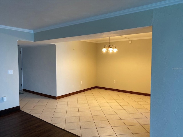 tiled spare room with a notable chandelier and ornamental molding