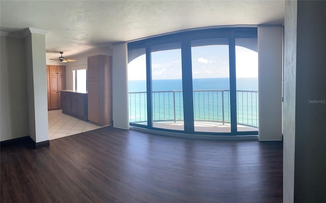 spare room with a water view, light hardwood / wood-style floors, and ceiling fan