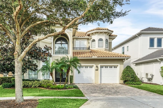 mediterranean / spanish home featuring a front lawn and a garage