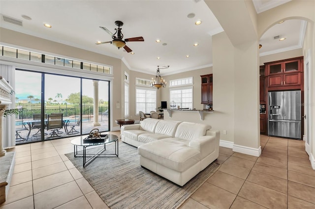 living room with ceiling fan with notable chandelier, light tile patterned flooring, and ornamental molding