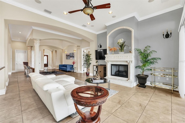 living room featuring ceiling fan, crown molding, light tile patterned floors, and ornate columns