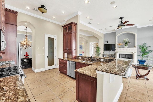 kitchen with dark stone countertops, light tile patterned flooring, stainless steel appliances, and ornamental molding