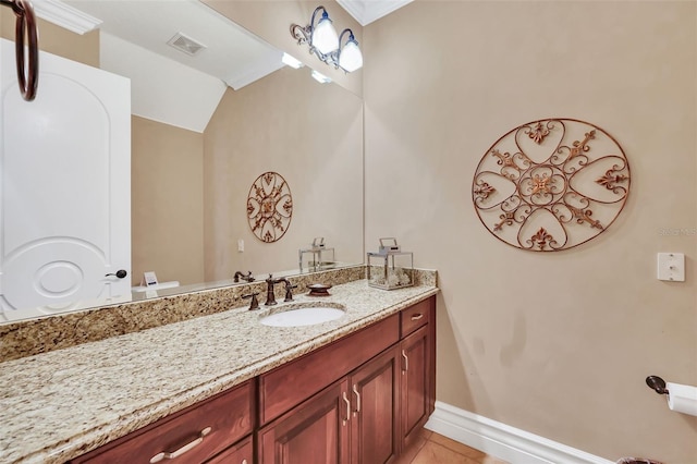 bathroom featuring vanity, lofted ceiling, tile patterned flooring, and ornamental molding