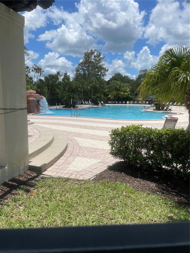 view of swimming pool featuring pool water feature and a patio