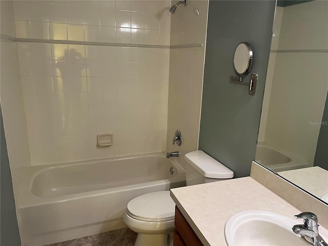 full bathroom featuring vanity, tiled shower / bath combo, and toilet