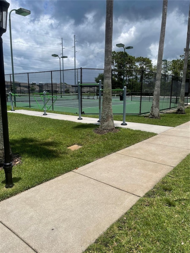 view of community with a lawn and tennis court