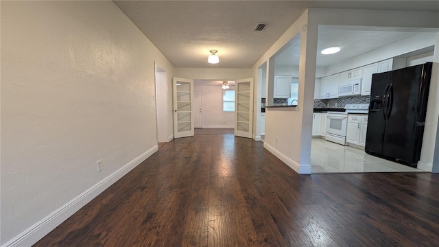 kitchen with decorative backsplash, wood-type flooring, white cabinetry, a textured ceiling, and white appliances