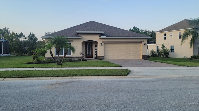 view of front of property featuring a front lawn and a garage