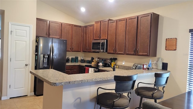 kitchen with lofted ceiling, a breakfast bar area, kitchen peninsula, stainless steel appliances, and light tile patterned flooring