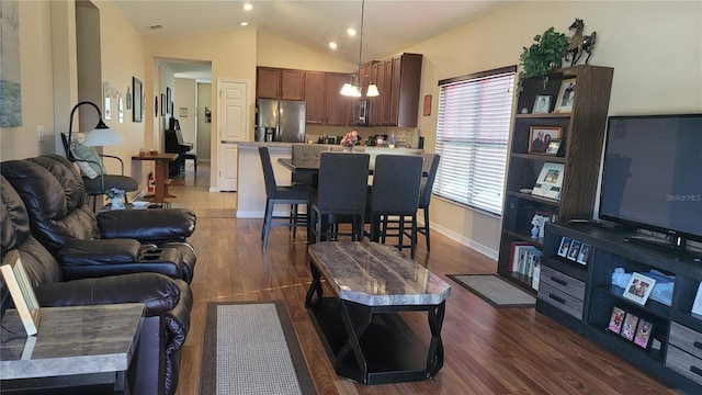 living room with dark wood-type flooring, a notable chandelier, and lofted ceiling