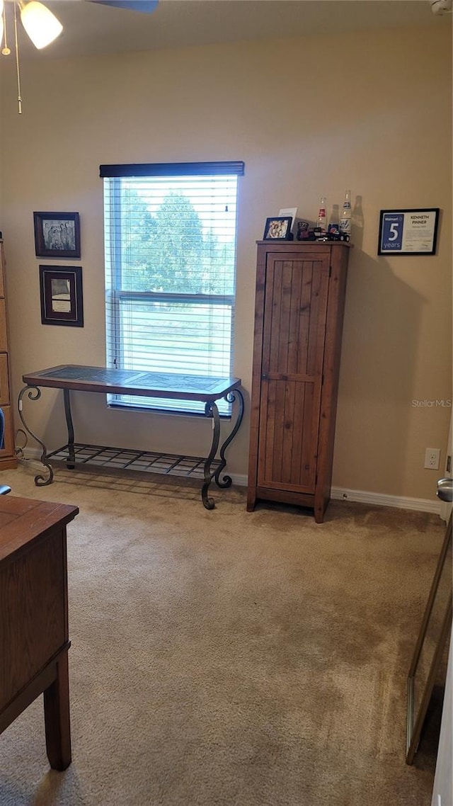 interior space featuring light carpet and ceiling fan