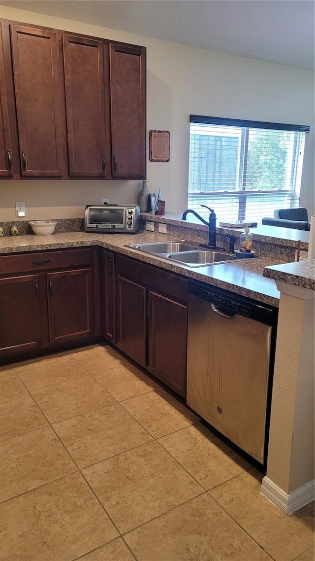 kitchen featuring dishwasher, dark brown cabinetry, sink, and light tile patterned floors