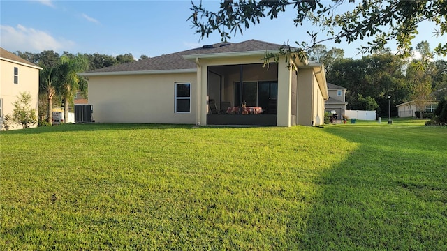 back of house with a yard, central air condition unit, and a sunroom