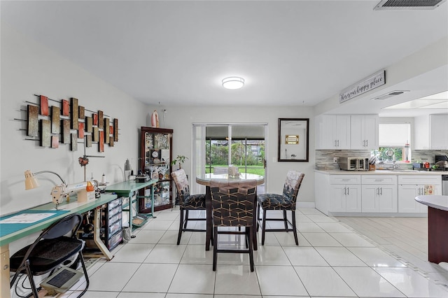 dining room featuring sink and light tile patterned floors