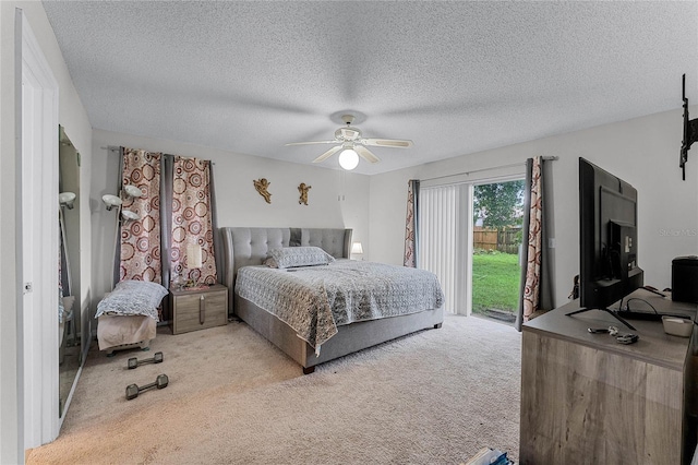 bedroom featuring a textured ceiling, light colored carpet, and ceiling fan