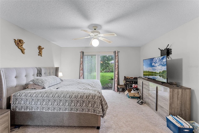 bedroom featuring ceiling fan, carpet flooring, access to outside, and a textured ceiling