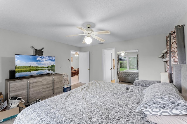 bedroom with a textured ceiling, carpet, and ceiling fan