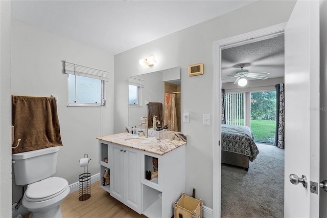 bathroom with hardwood / wood-style flooring, toilet, a shower with curtain, vanity, and ceiling fan