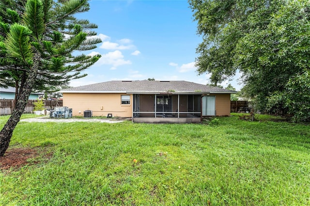 back of property featuring a yard, a sunroom, and cooling unit