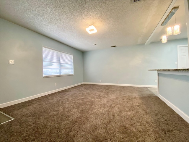 empty room featuring dark colored carpet and a textured ceiling