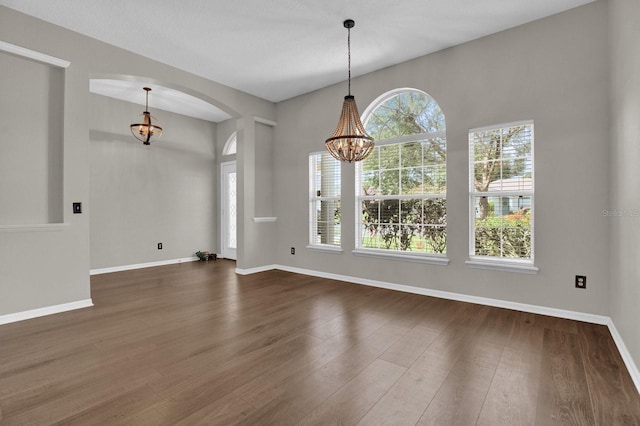 unfurnished dining area featuring dark hardwood / wood-style floors and a notable chandelier