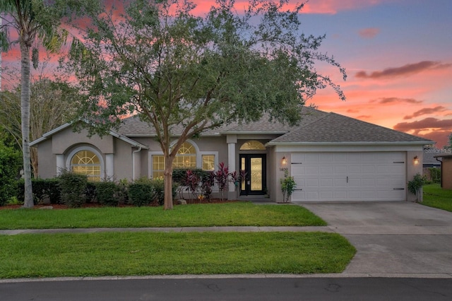 view of front facade with a garage and a yard