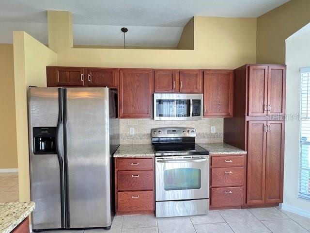 kitchen with light stone counters, appliances with stainless steel finishes, plenty of natural light, and light tile patterned floors