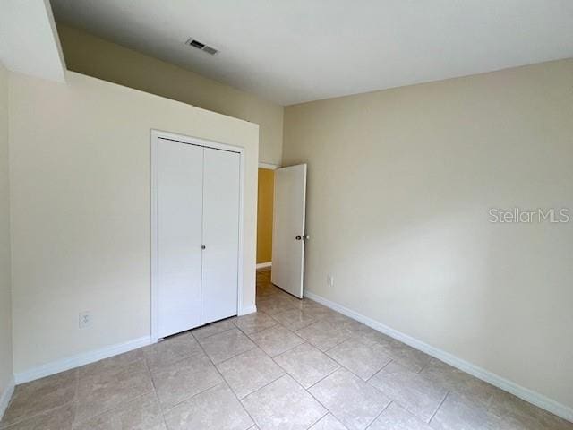 unfurnished bedroom with a closet and light tile patterned floors