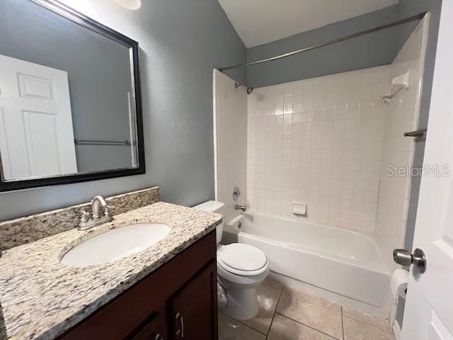 full bathroom featuring tile patterned flooring, tiled shower / bath combo, vanity, and toilet