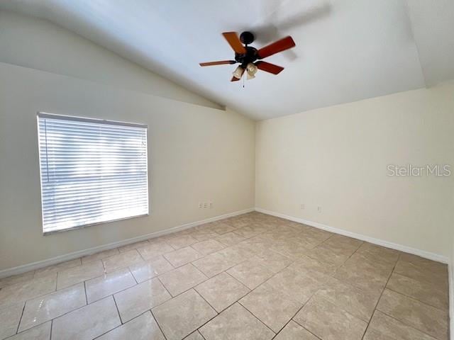 tiled empty room featuring vaulted ceiling and ceiling fan