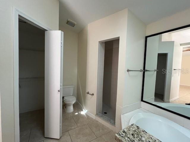 bathroom featuring independent shower and bath, toilet, and tile patterned floors