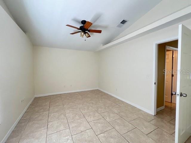 empty room with light tile patterned floors, lofted ceiling, and ceiling fan