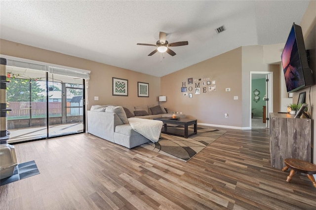 living room with hardwood / wood-style floors, vaulted ceiling, a textured ceiling, and ceiling fan