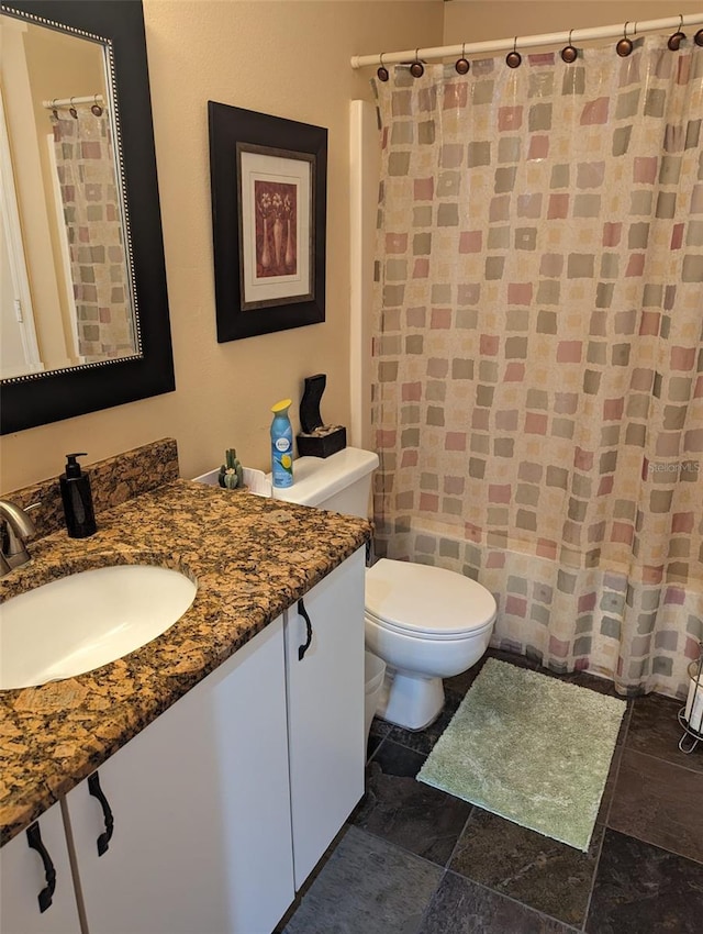 bathroom featuring a shower with shower curtain, vanity, and toilet