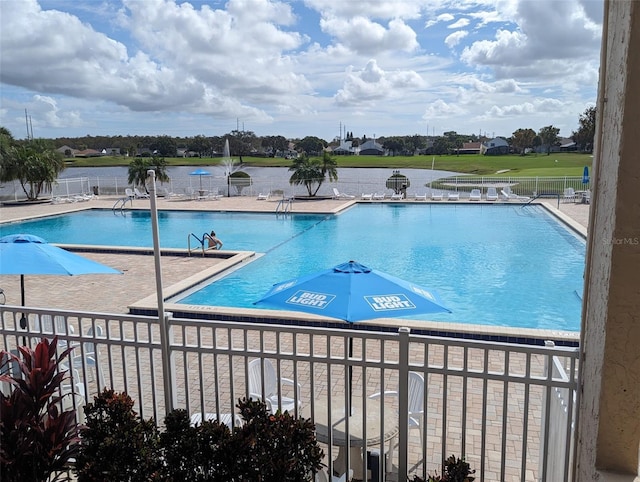 view of pool featuring a patio area and a water view