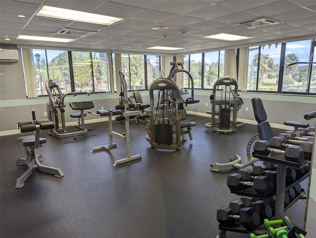 exercise room with a paneled ceiling and a wall unit AC